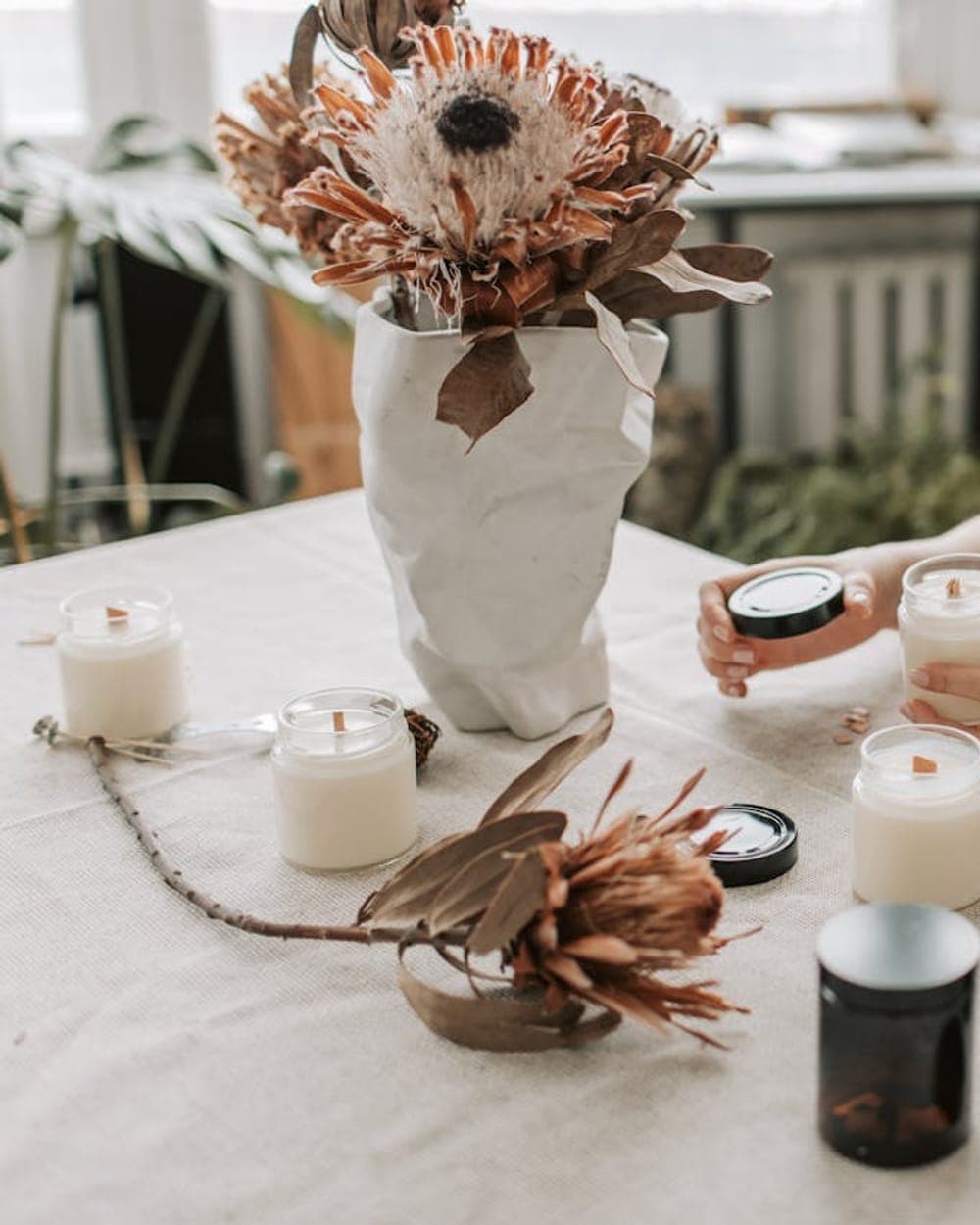 Bancada do atelier, com velas acabadas e flores secas